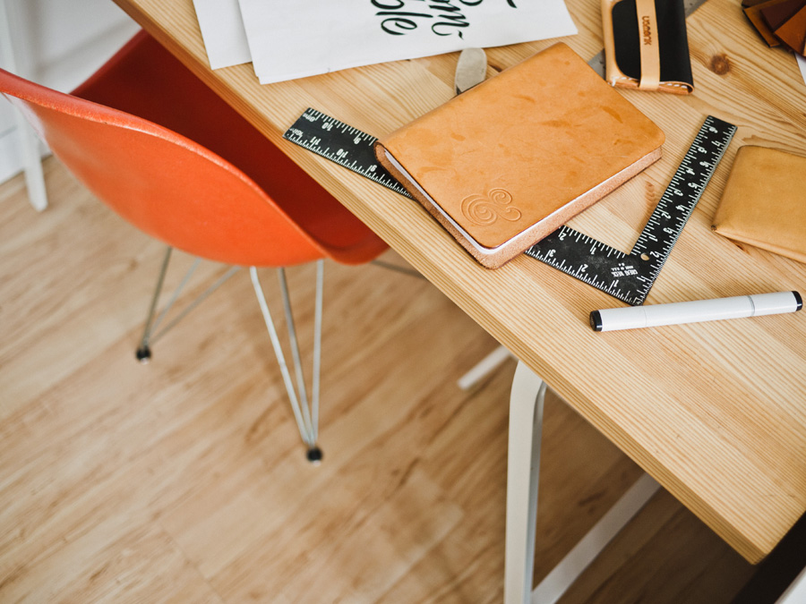 desk with office supplies and a red chair